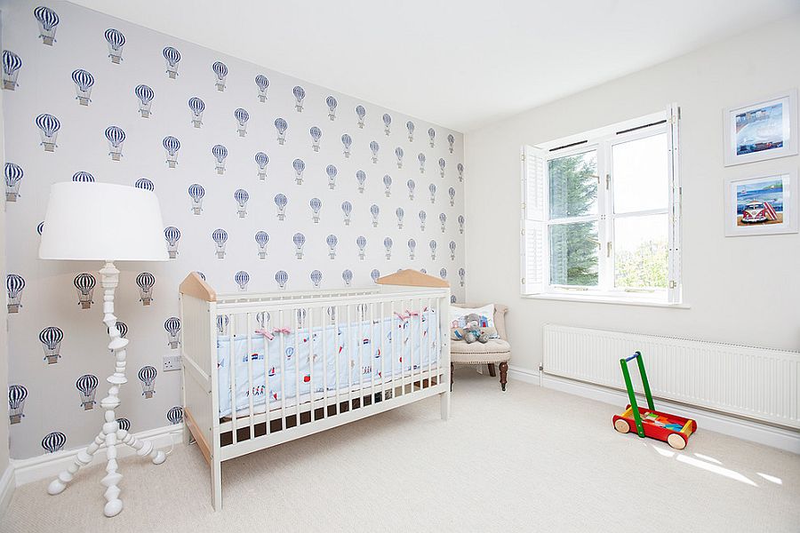 Beach style nursery in white with wallpaper that carries air balloon motif