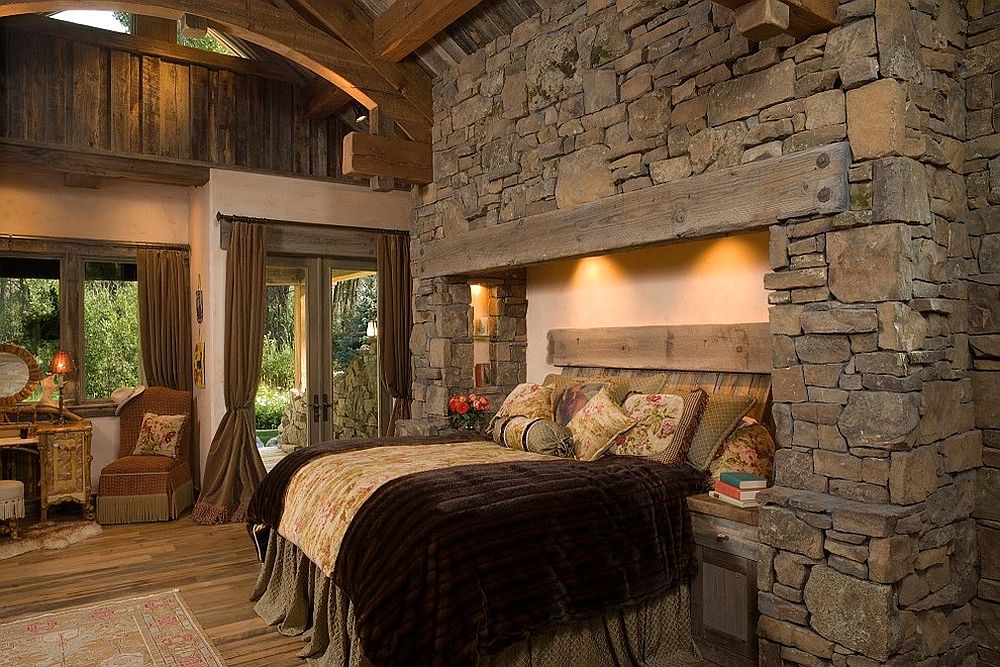 Bed built into a wall of rock and stone for a unique rustic bedroom
