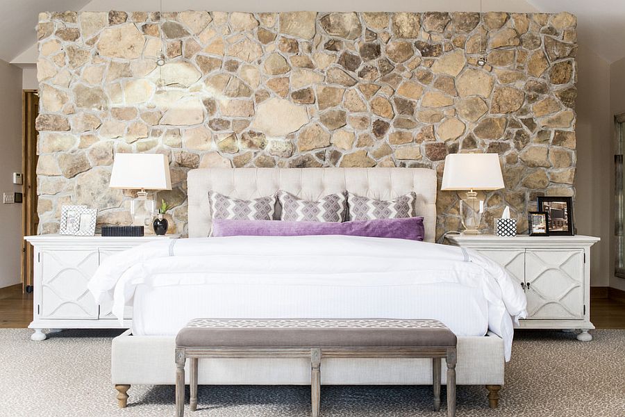 Bedside tables bring symmetry to the contemporary bedroom with stone wall