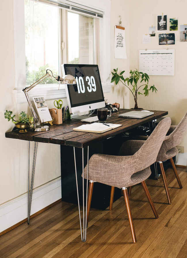 Bright office space with wood desk and touches of greenery