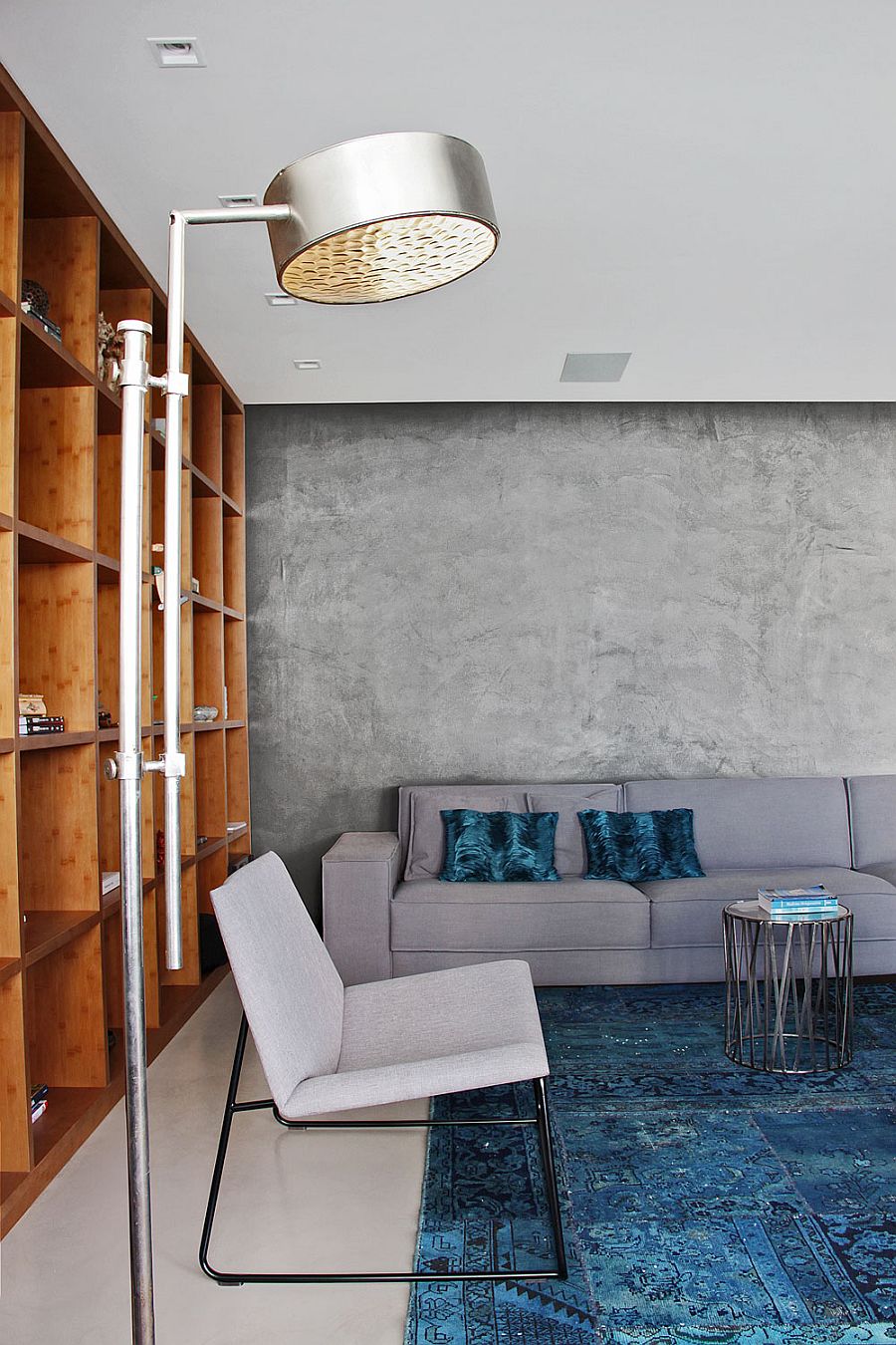 Contemporary couch in gray blends into the cement wall backdrop