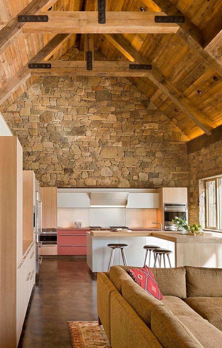 Contemporary island in white and cabinets combined with a captivating rustic backdrop in the kitchen