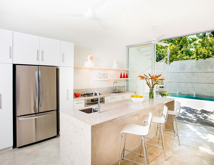 Contemporary kitchen in white connected with the courtyard outside