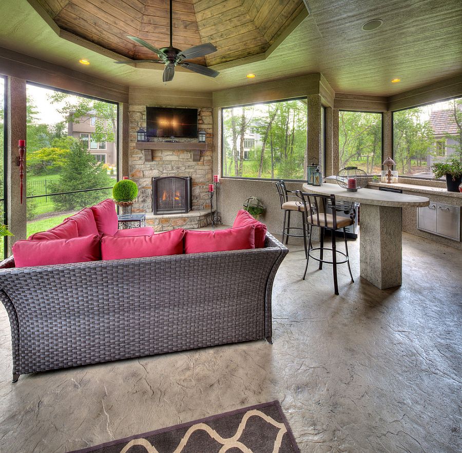 Cozy sunroom with fireplace, plush couch, innovative ceiling design and TV [Design: Starr Homes]