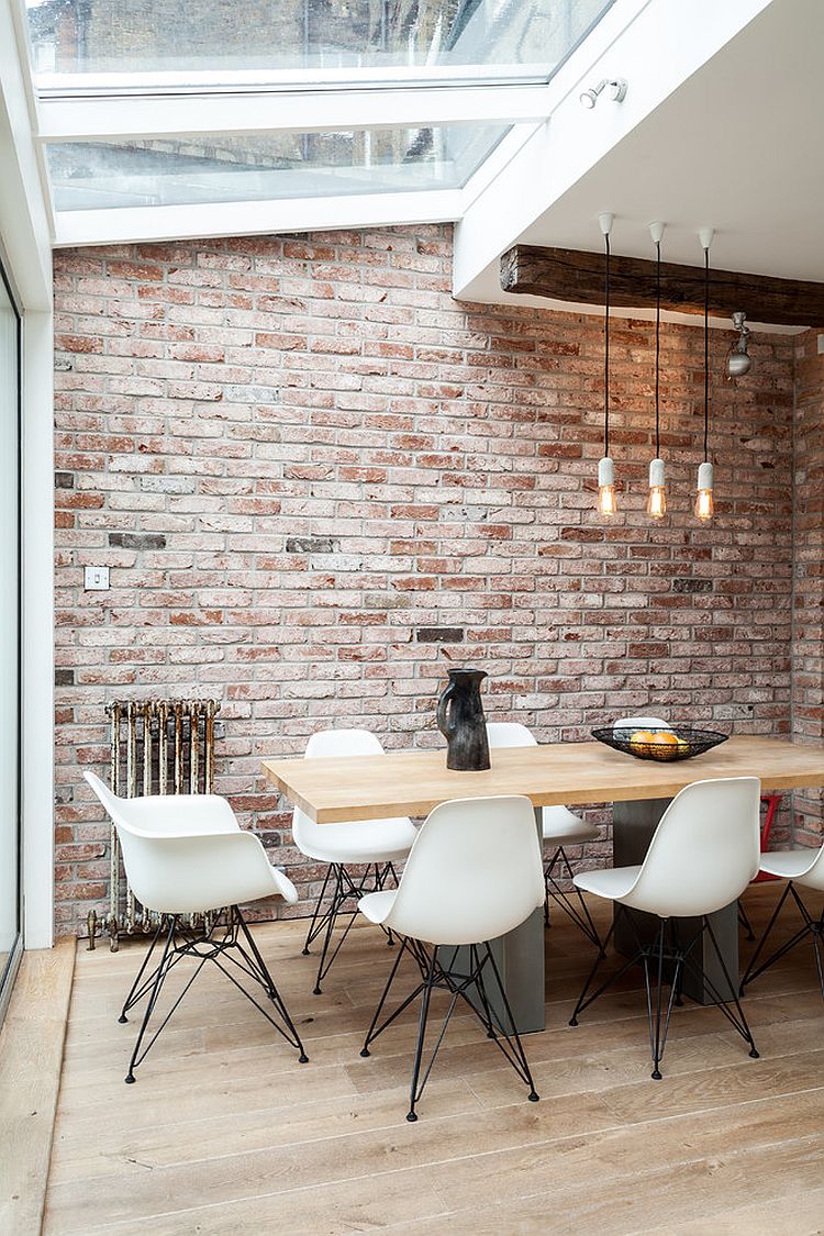 Dining space in the corner of industrial living area with conservatory roof