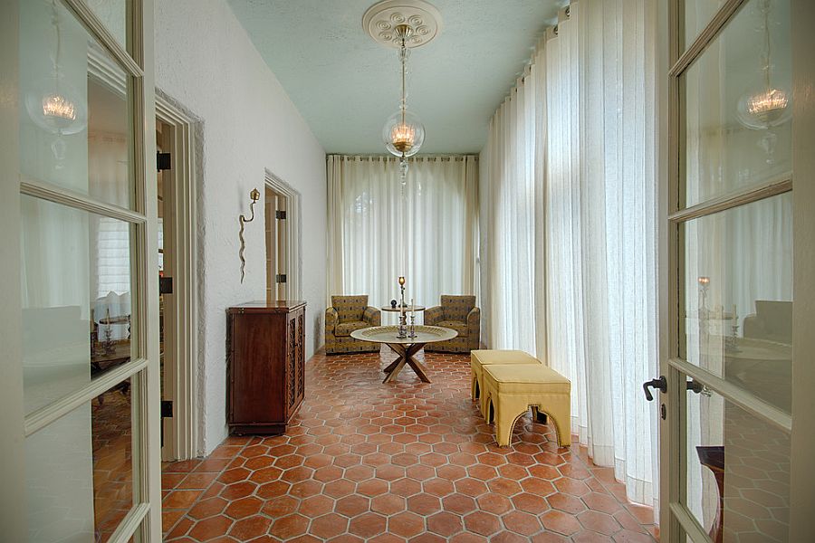 Drapes control the flood of sunlight as terracotta tiles bring Mediterranean elegance to the sunroom