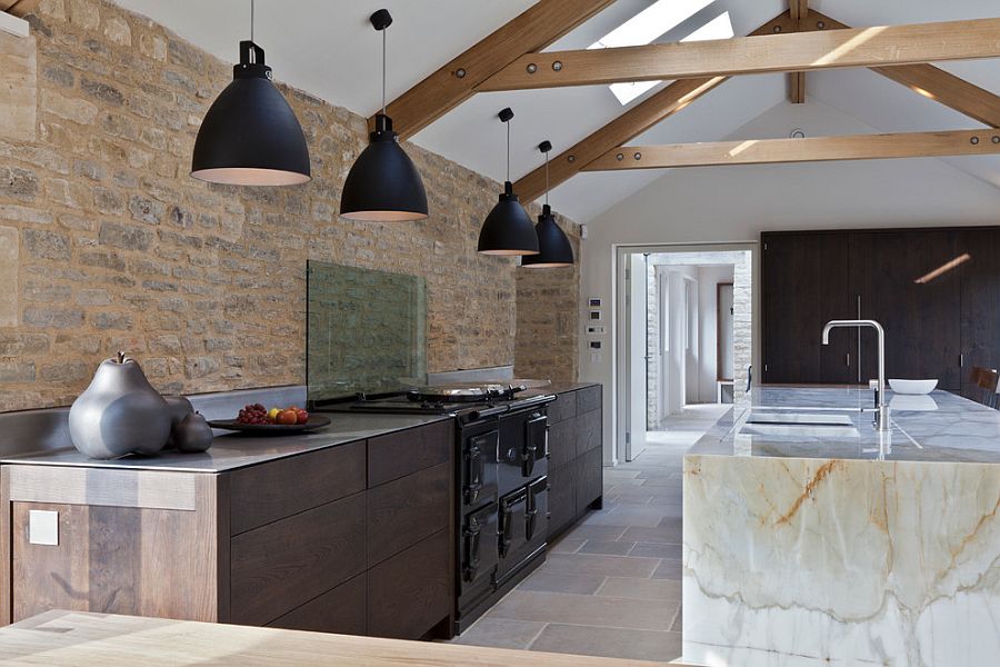 Exposed original stonework of contemporary kitchen inside an old barn turned into modern home