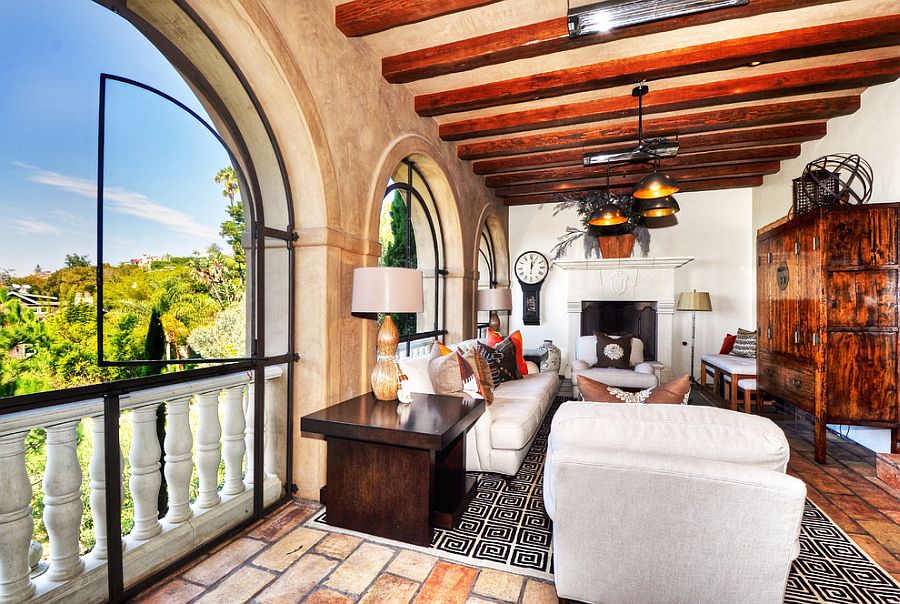 Exposed wooden beams, textured walls and arched windows shape a stylish sunroom [From: Bowman Group Architectural Photography]