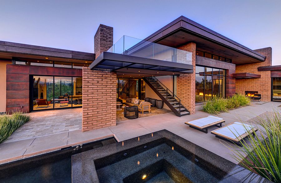 Exterior of desert home with adobe walls and rusted steel panels