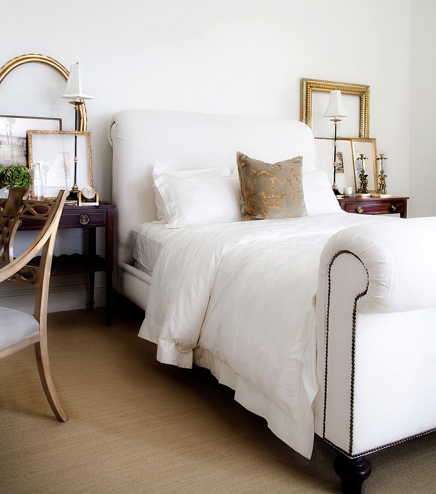 Gold frames bring sparkle and symmetry to this all-white bedroom [Design: Jessica Bennett Interiors]