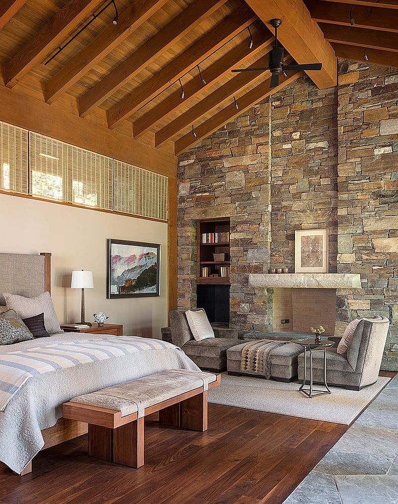 Imposing stone wall adds to the dramatic ambiance of the bedroom