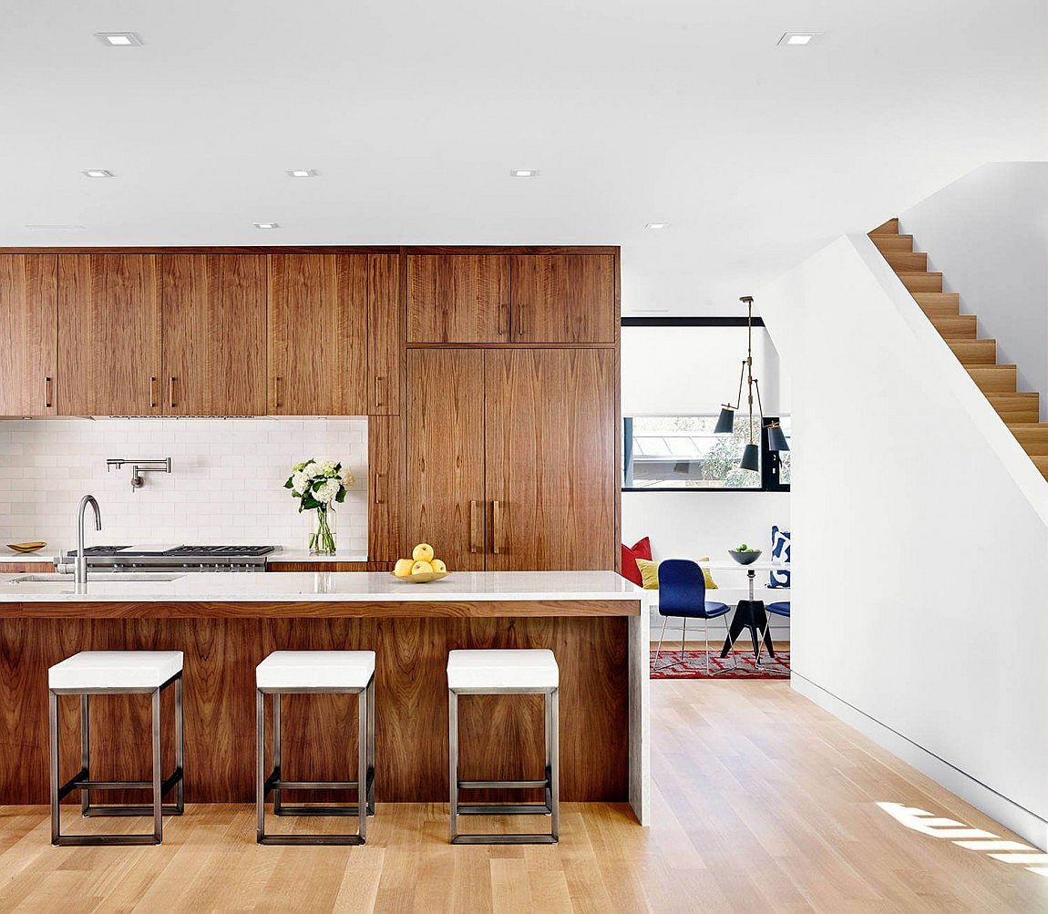 Kitchen draped in walnut veneer brings warmth to the modern interior