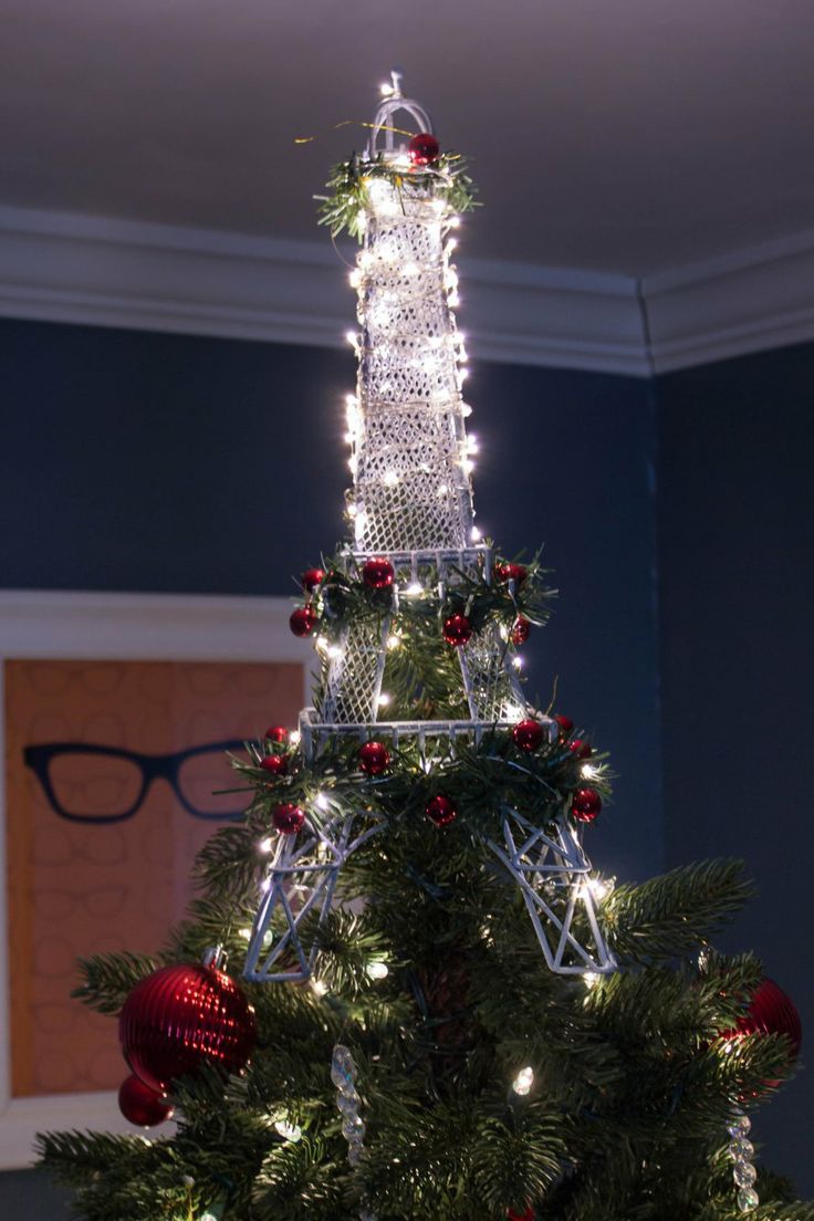 Large Eiffel Tower tree topper lit up with lights