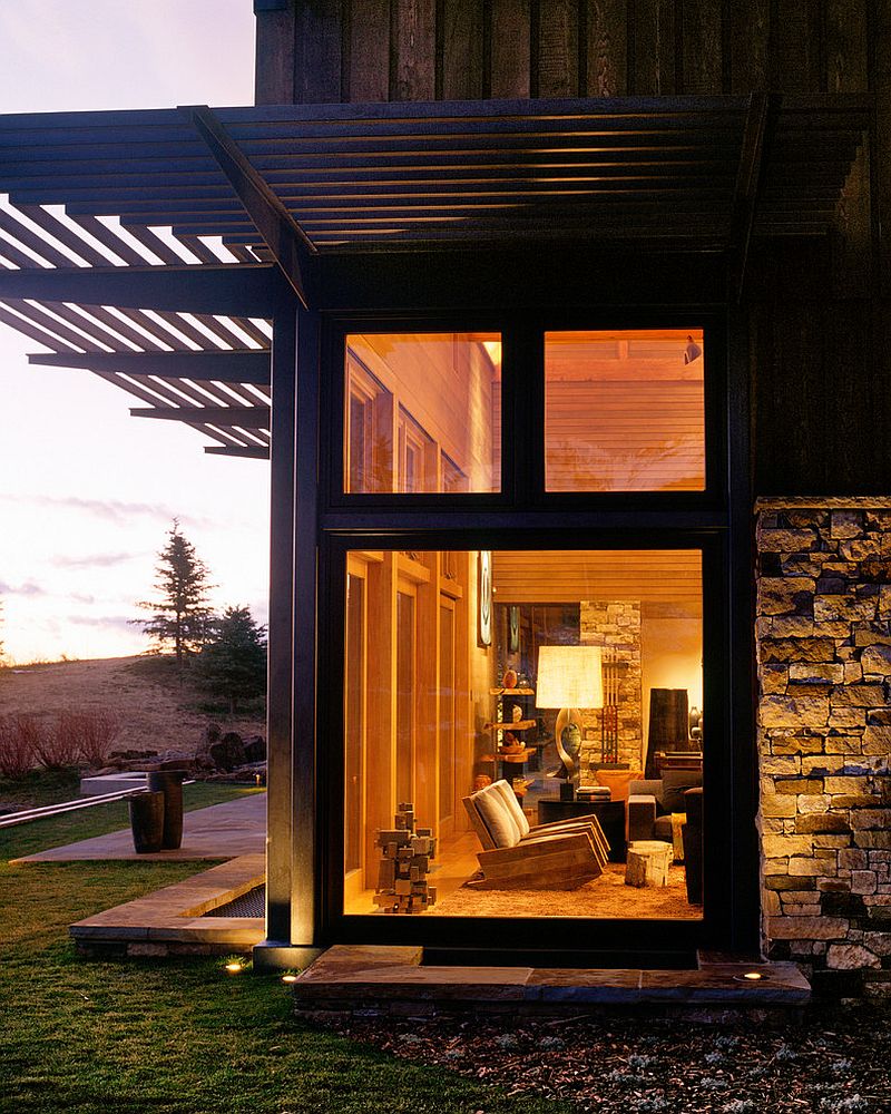 Large glass windows bring a dash of modernity to the stone and wood mountain home