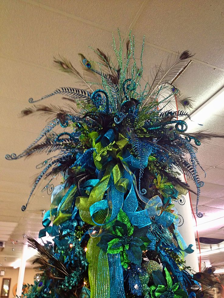 Large peacock-inspired tree topper with lots of blue and green ribbon