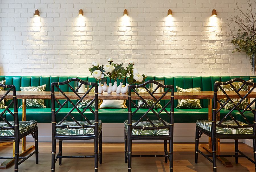 Lighting highlights the beauty of the painted brick wall in the dining room