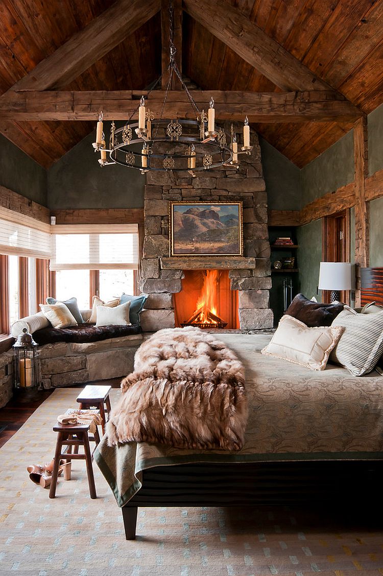 Lovely stone wall fireplace and window seat enhance the woodsy cabin style of the bedroom [Design: Yellowstone Traditions]