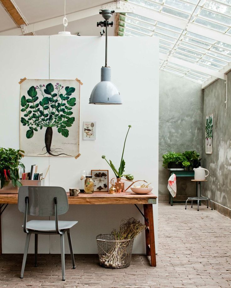 Nature-inspired painting hung above a desk in a greenhouse