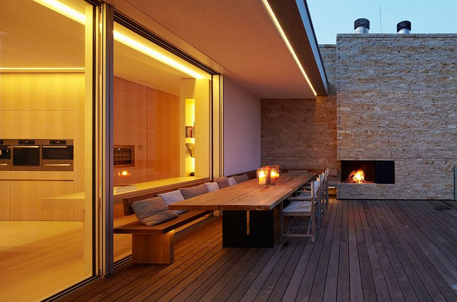 Outdoor dining area next to the fireplace on wooden deck with lake views