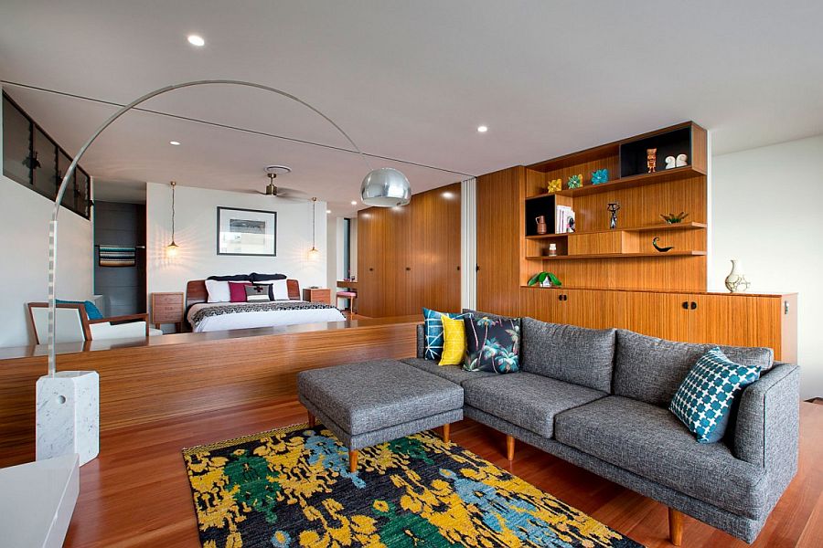 Plush couch for the bedroom sitting zone with pops of yellow brought in by the rug and accent pillows