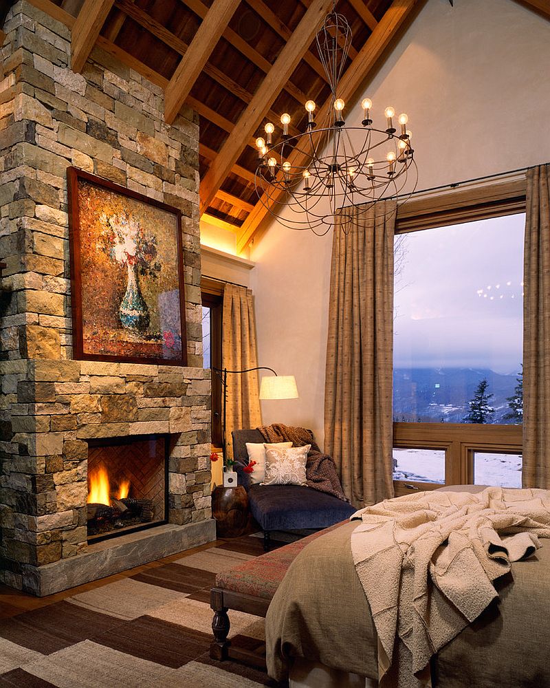 Rustic bedroom with cozy stone fireplace and mountain view