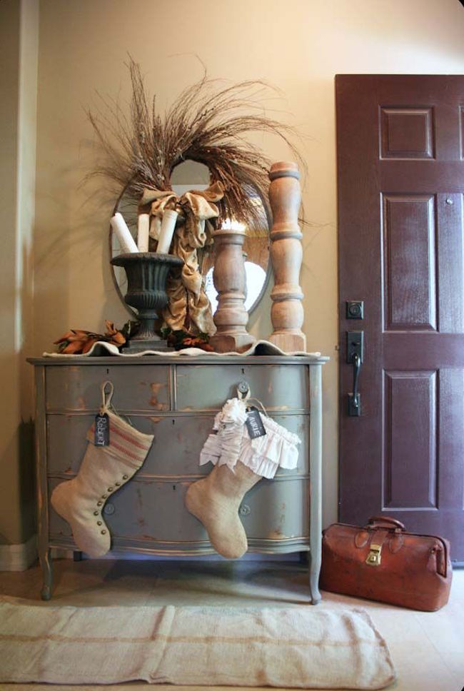 Rustic stockings hung on entryway dresser knobs