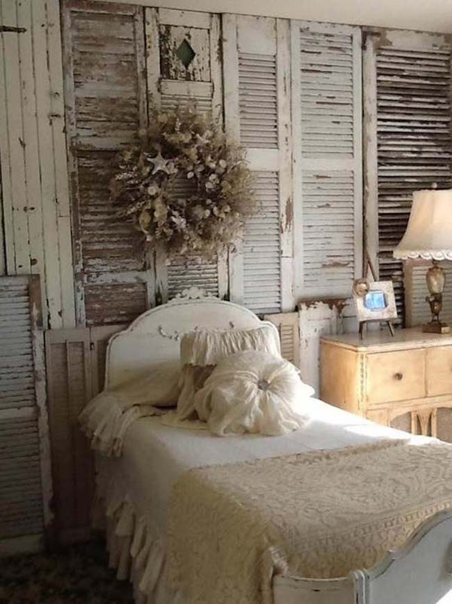 Shabby chic bedroom with entire wall full of vintage shutters