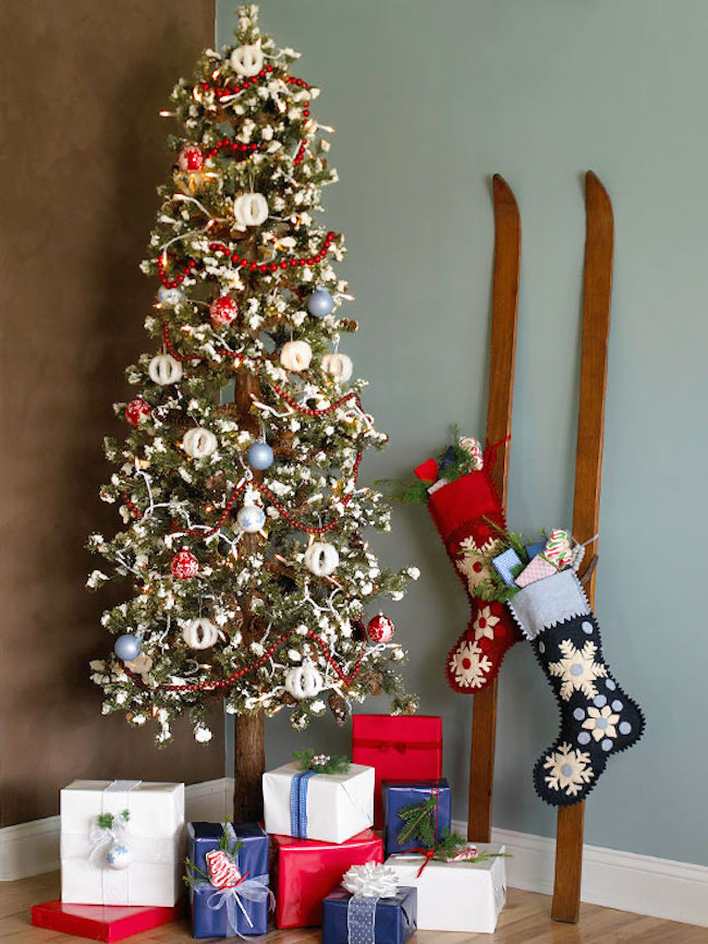 Skis with stockings hung on them next to Christmas tree