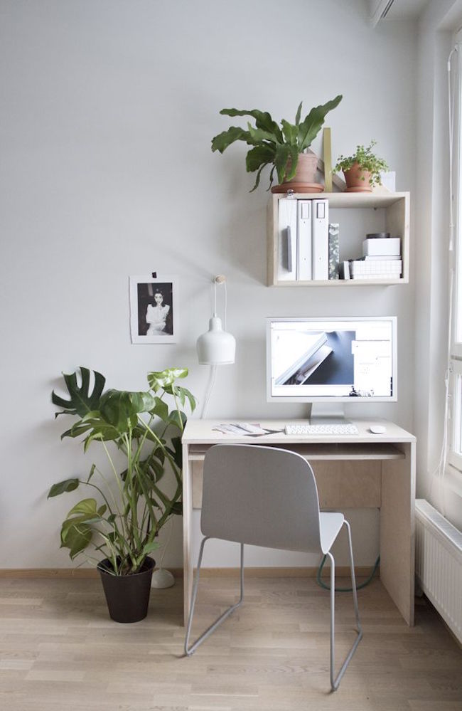 Small desk near a bright window with touches of greenery