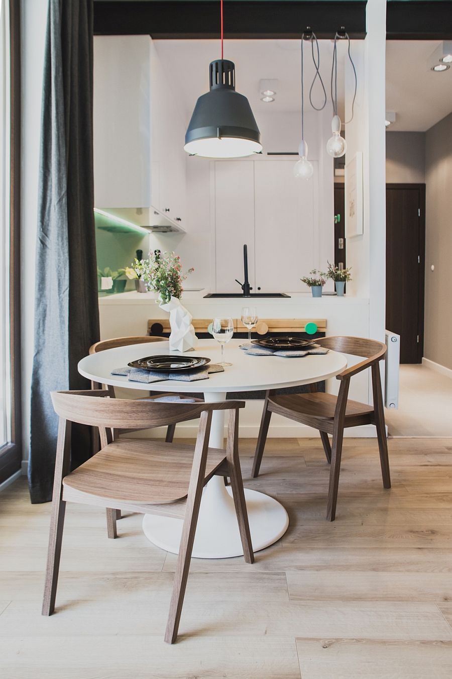 Small dining space for space-savvy apartment with round table and pendant light in gray