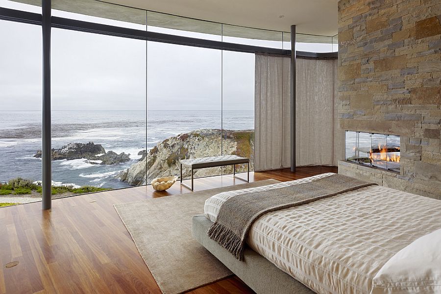 Stone wall in the contemporary bedroom complements the rugged landscape outside