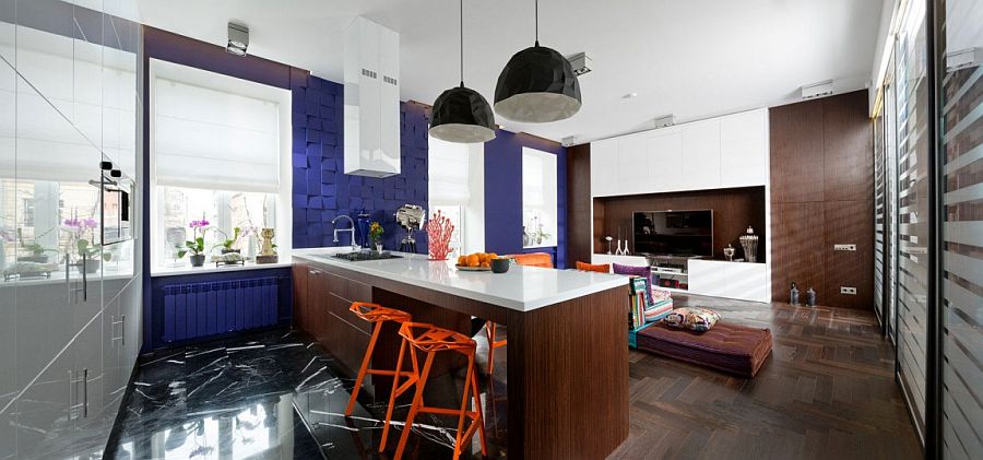 Textured wall with custom 3d Panels in blue and snazzy Konstantin Grcic orange chairs shape the eclectic apartment