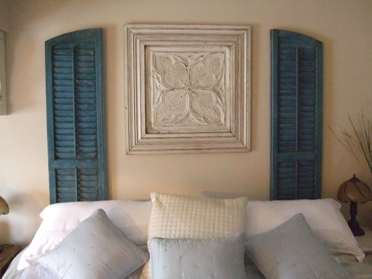 Vintage shutters and artwork used in place of a headboard