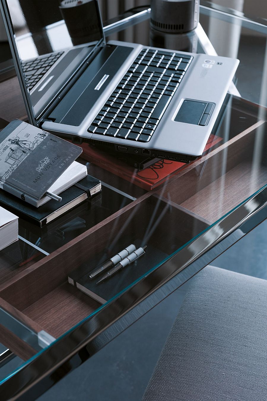 Walnut drawer of the desk under the glass desk top