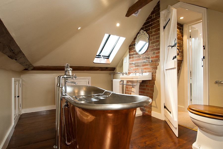 Attic bathroom with exposed brick wall and copper bathtub