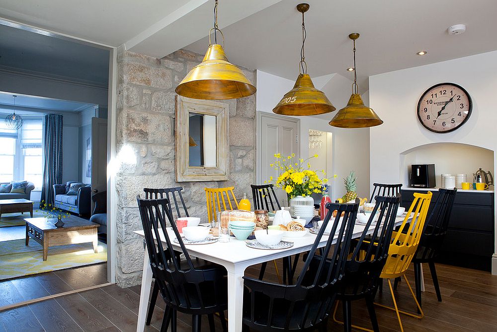 Beach style dining room with accent stone wall and colorful chairs [Design: Camellia Interiors]