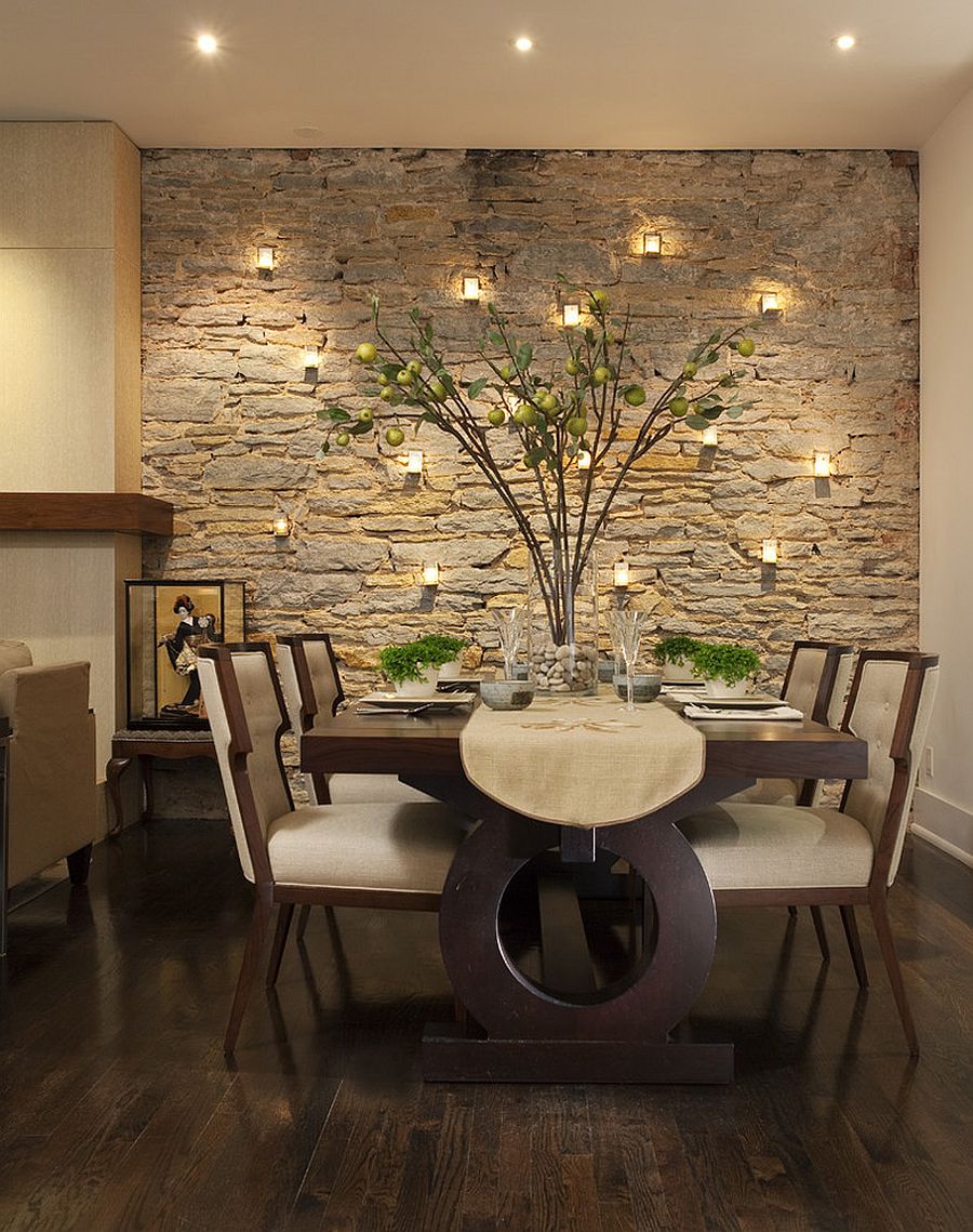 Candles highlight the beauty of the stone wall in the dining room [Design: Charlie & Co. Design]