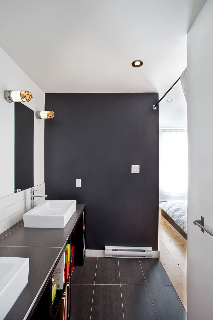 Dark bathroom connected with the white master bedroom provides visual contrast