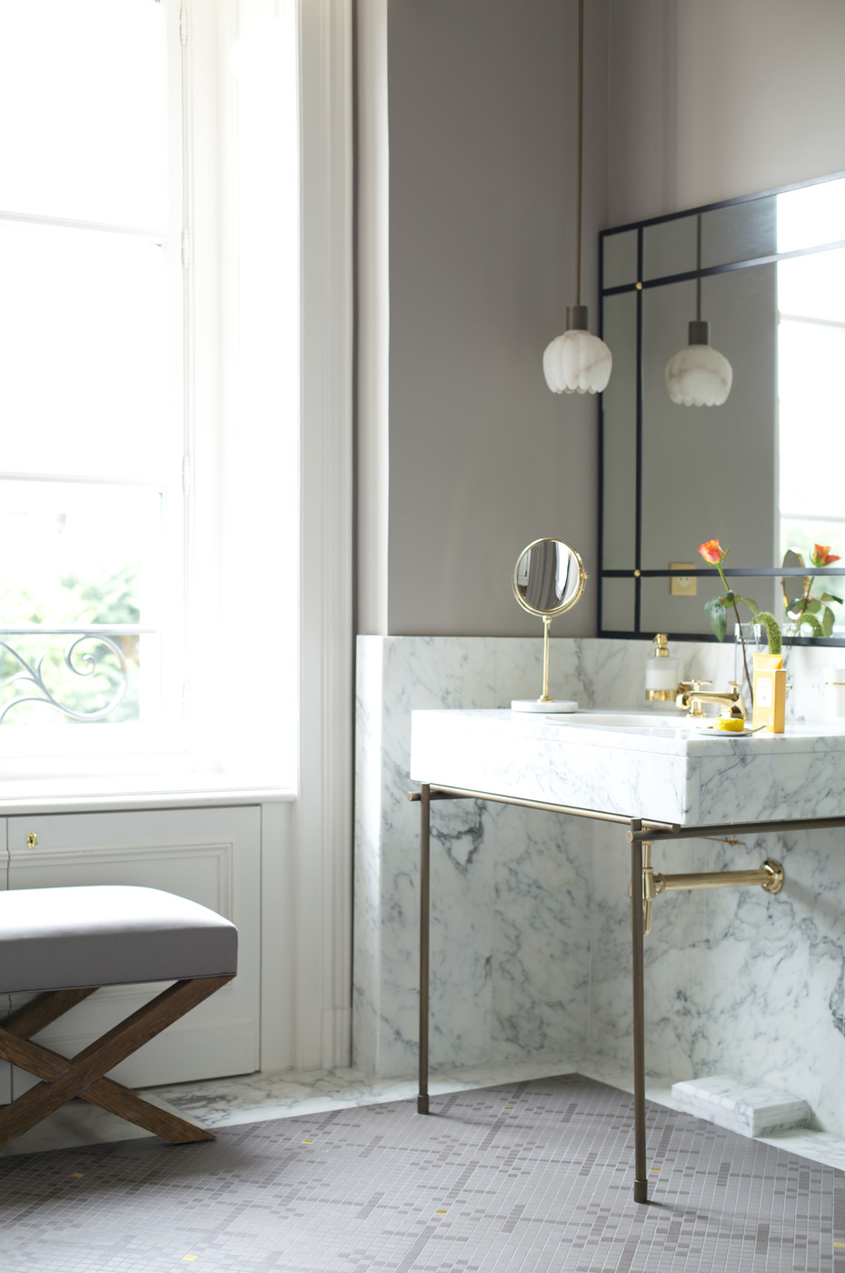 Delicate pendant lighting in a powder room with marble detailing