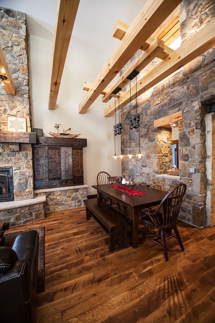 Farmhouse style dining room with wooden beams, stone walls and ingenious lighting