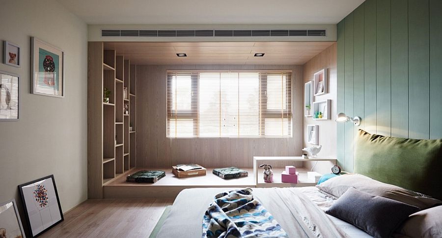 Floor cushions and an elevated wooden platfor create a simple reading zone in the bedroom