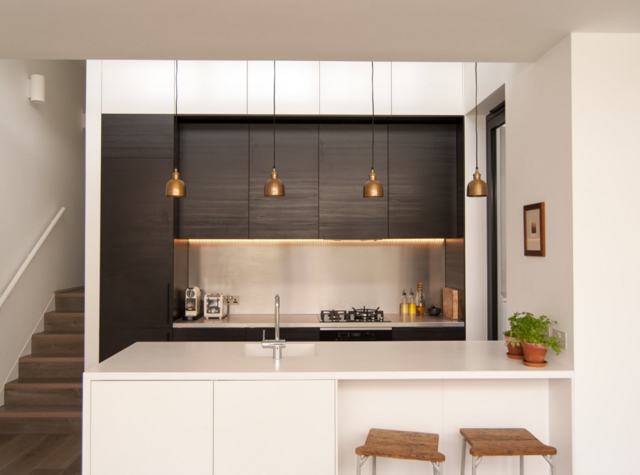 Modern kitchen with a series of brass pendants