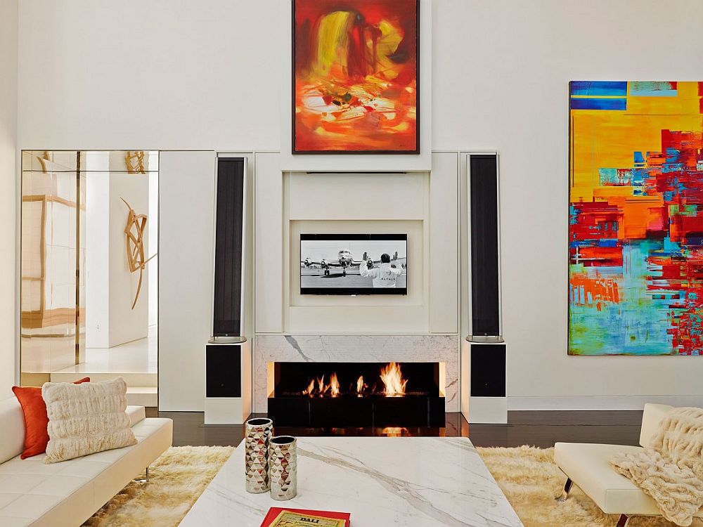 Sliding frames open up to reveal the hidden TV above fireplace