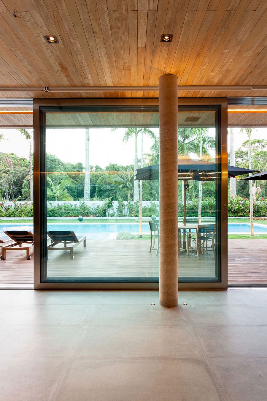 Sliding glass doors connect the pavilion with the pool area