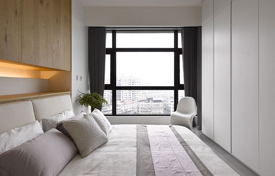 Small bedrooom in white opens up to the city view outside