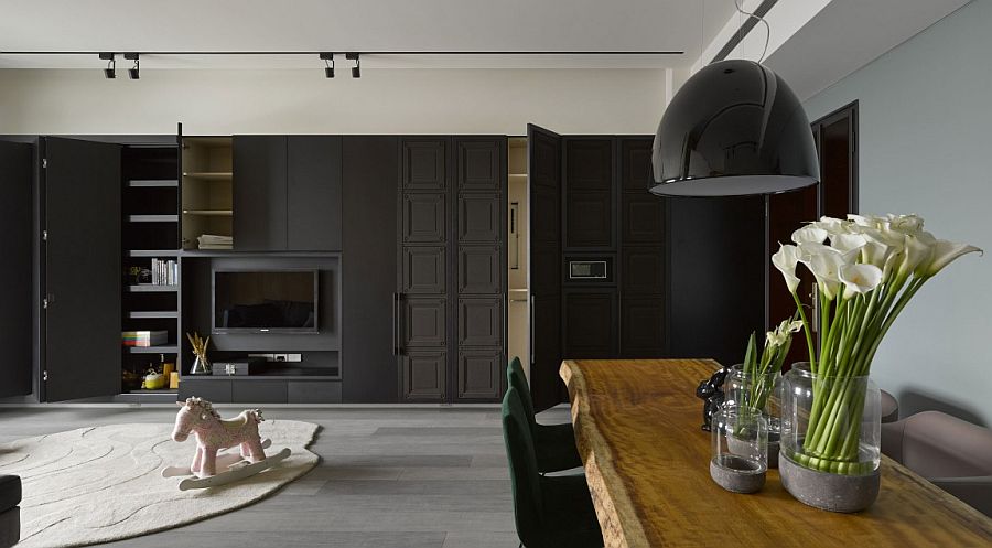 Smart cabinets in the living area blend into the dark backdrop seamlessly