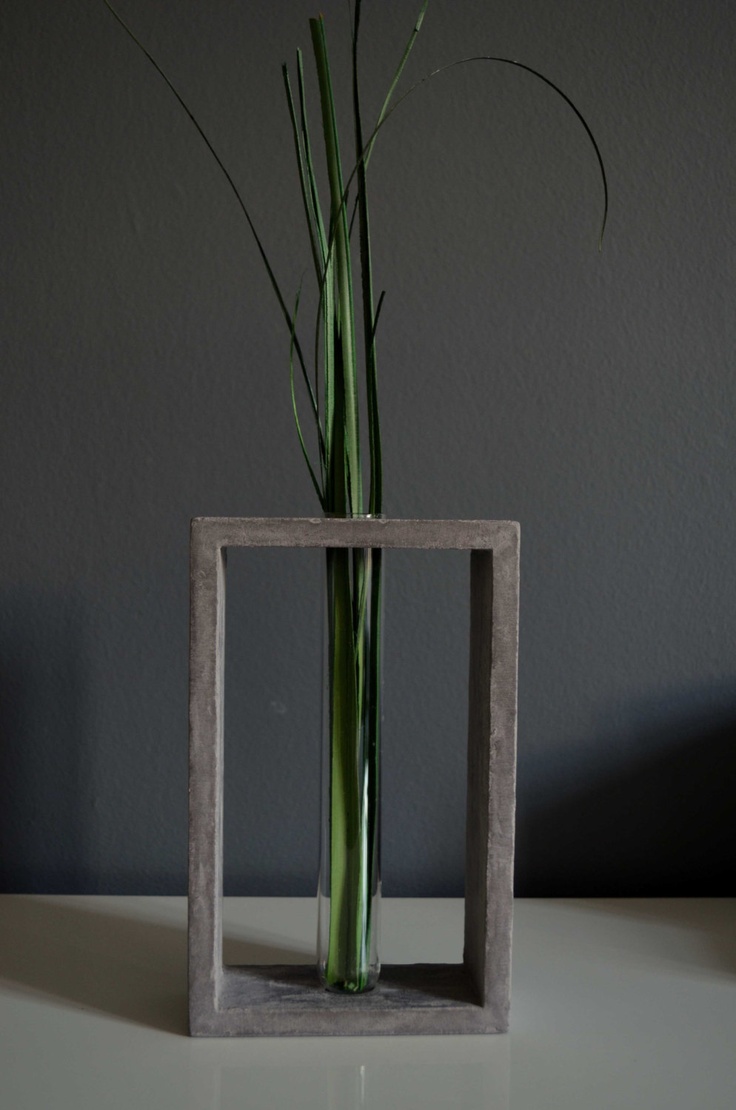 Transparent glass tube vase in grey concrete stand