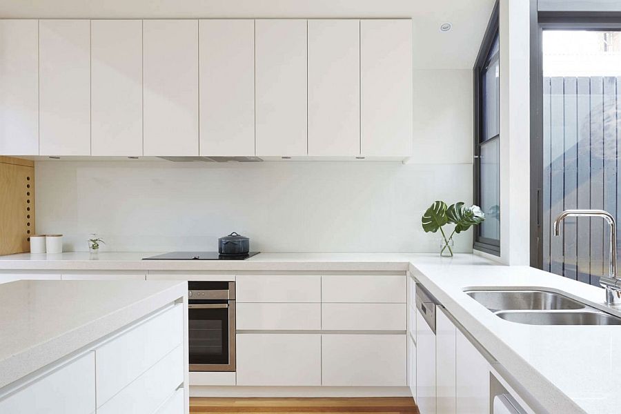 All-white contemporary kitchen with smart central island and ample cabinet space