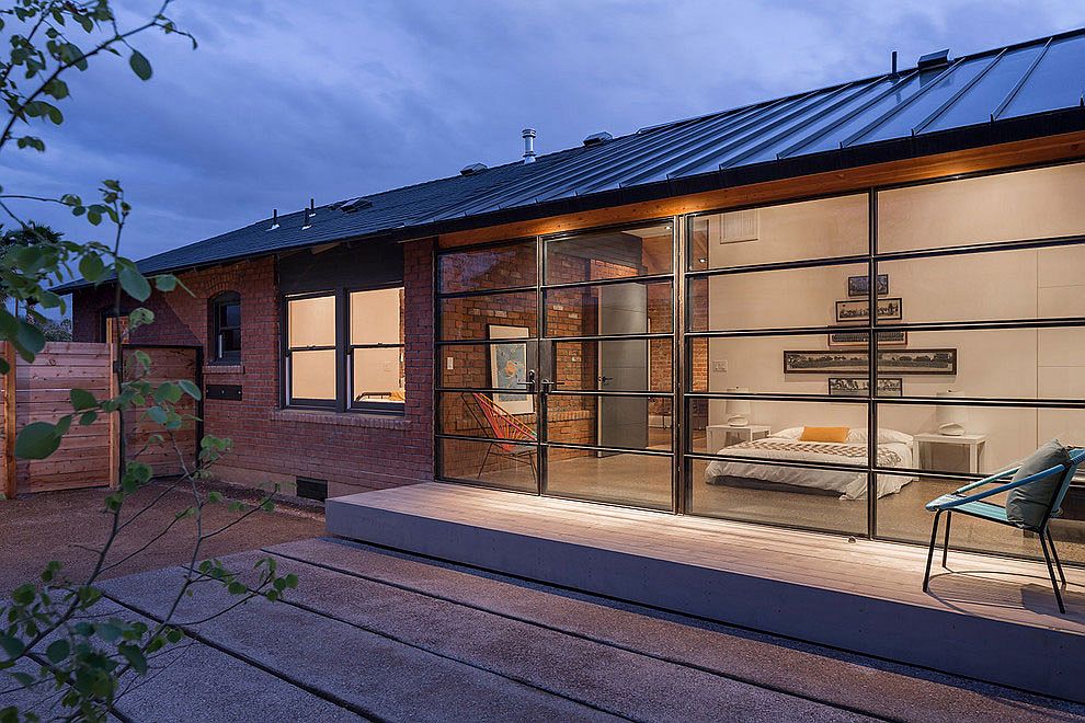 Contemporary glass and steel extension sits next to old brick, Carriage House in Phoenix