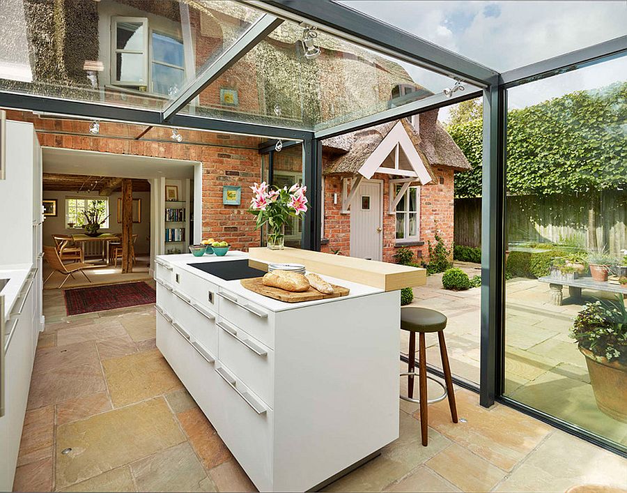 Glass box kitchen lets in natural light and illuminates the foyer indoors